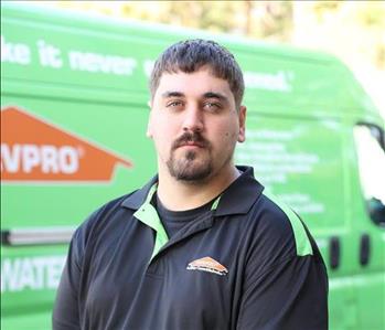 Male, brown hair, mustache and beard, wearing black and green Servpro shirt with logo 